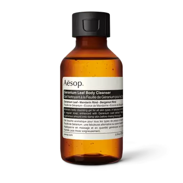 Aesop Geranium Leaf Body Cleanser in a small amber bottle with a black flip-top cap and cream label on a white background.