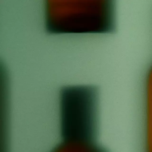 Soft-focus amber fragrance bottles with dark caps against a pale green backdrop, creating a blurred repeating horizontal pattern.