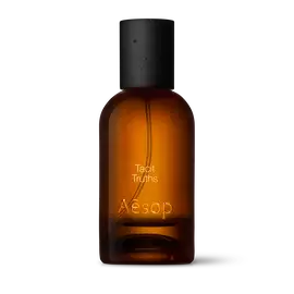 Amber glass Aesop Tacit Truths Eau de Parfum bottle with black cap on a white background.