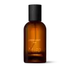 Amber glass Aesop Unforeseen Aer Eau de Parfum bottle with black cap on a white background.
