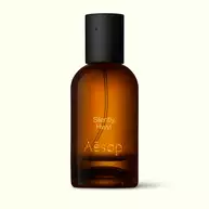 Amber glass Aesop Silently Hwyl Eau de Parfum bottle with black cap on a white background.