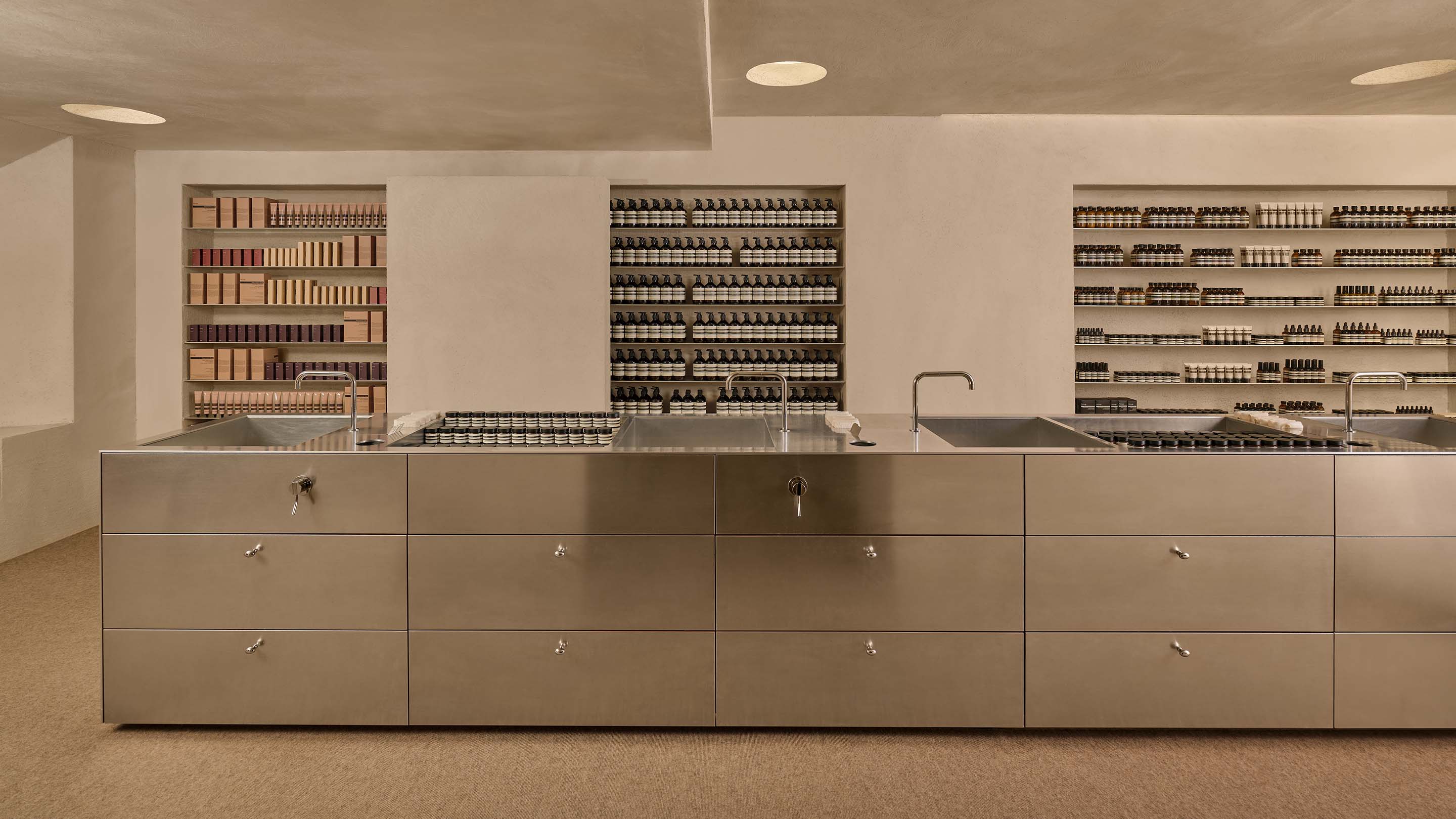 store interior view of island counter with multiple sinks and grey drawers in the under the counter top