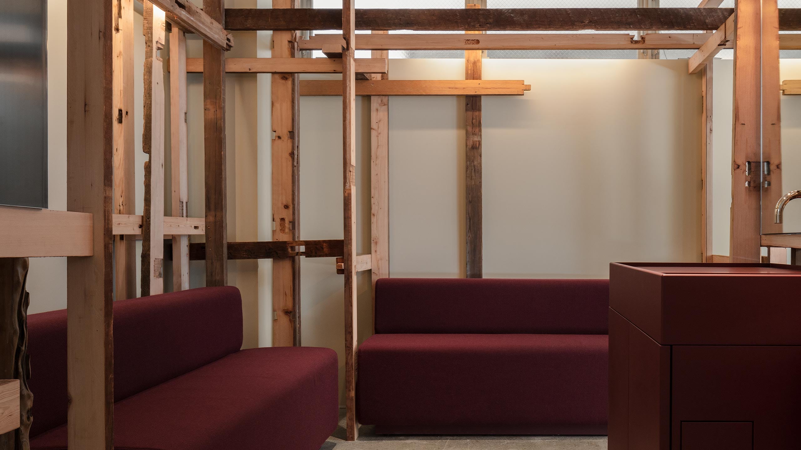A series of shelves staggered throughout the space with two ample bench and a red urushi (lacquer) basin