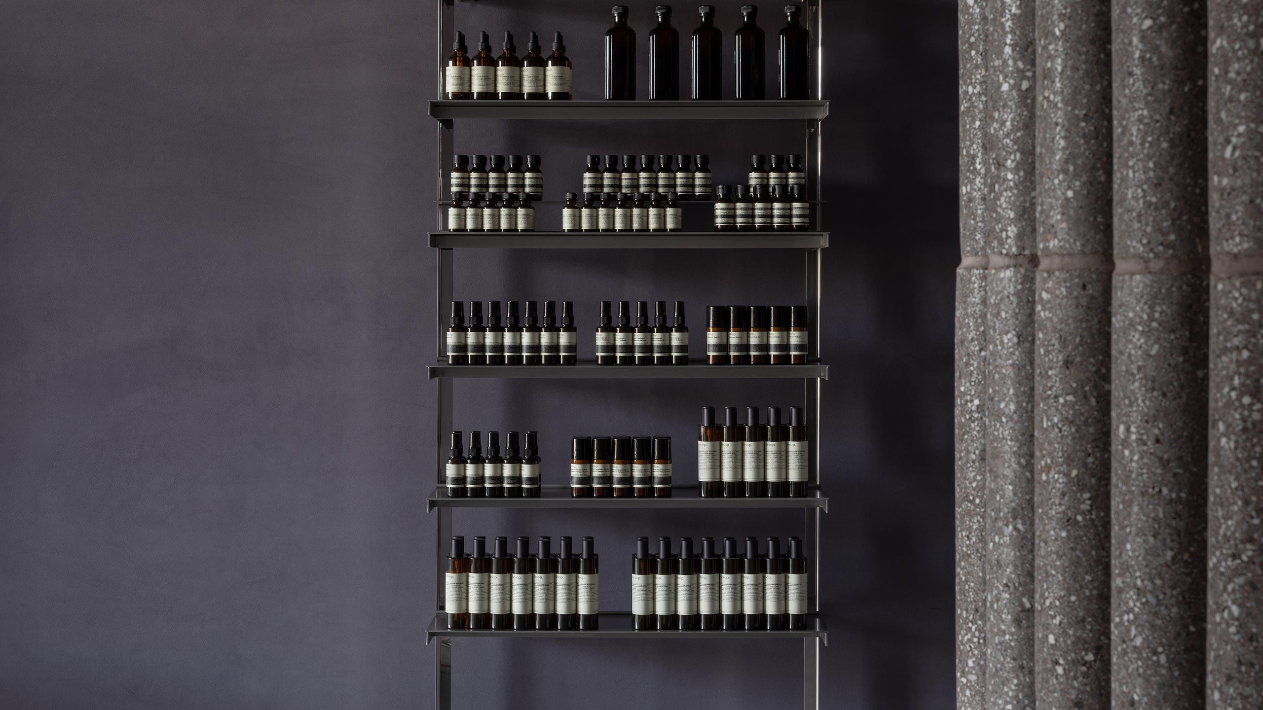 A close-up shot of steel shelving holding Aesop product