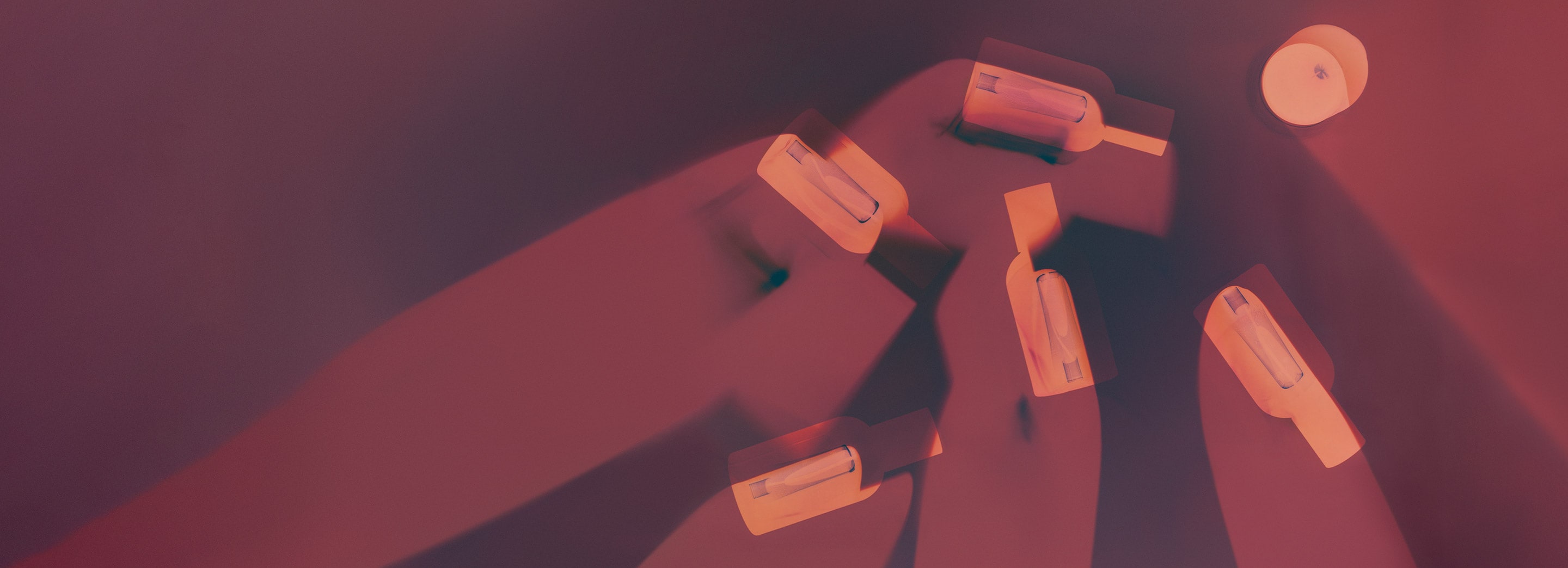 A shape of Aesop fragrance bottles placed on a dark red background