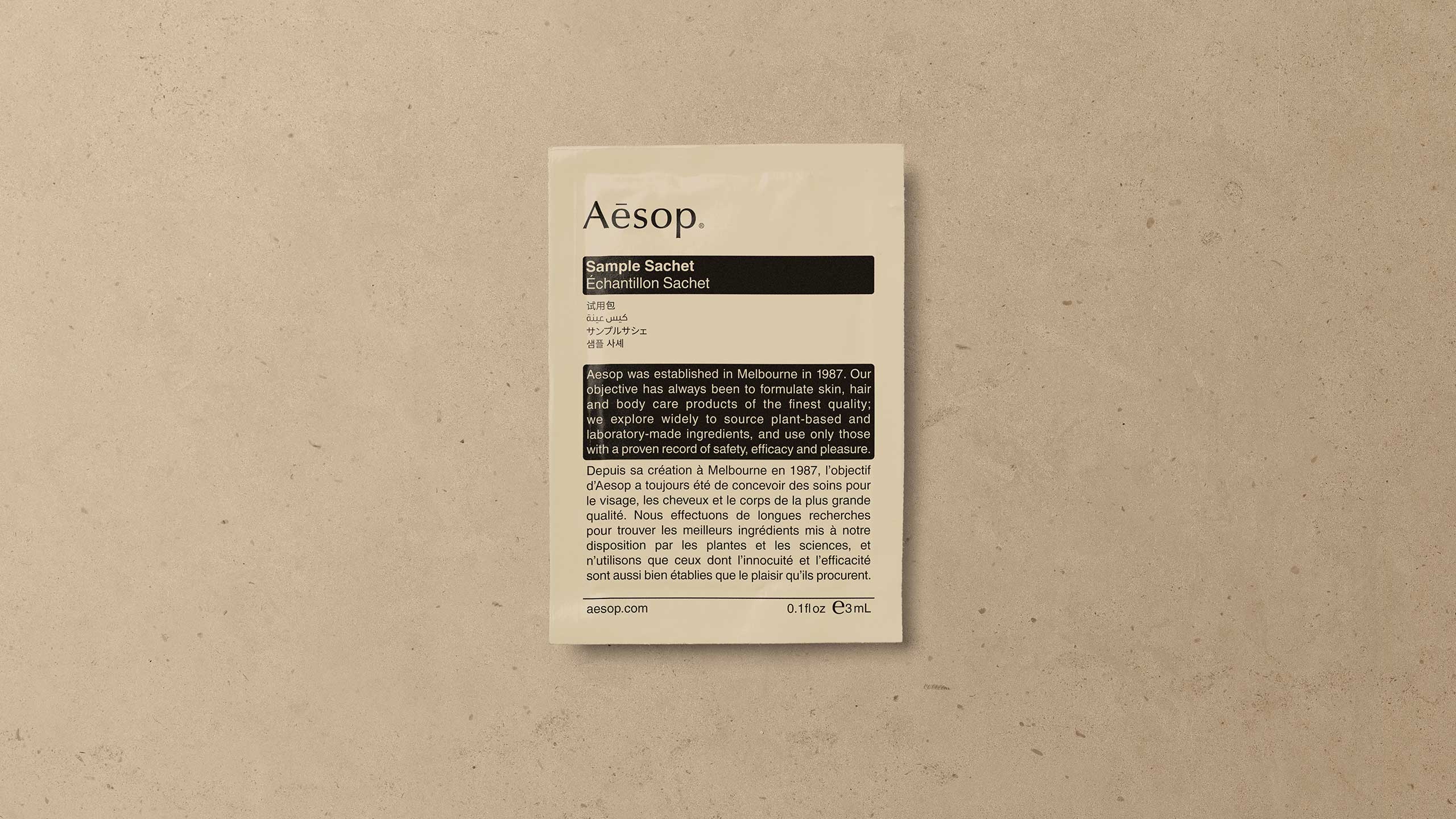 Aesop sample sachet placed on a beige surface