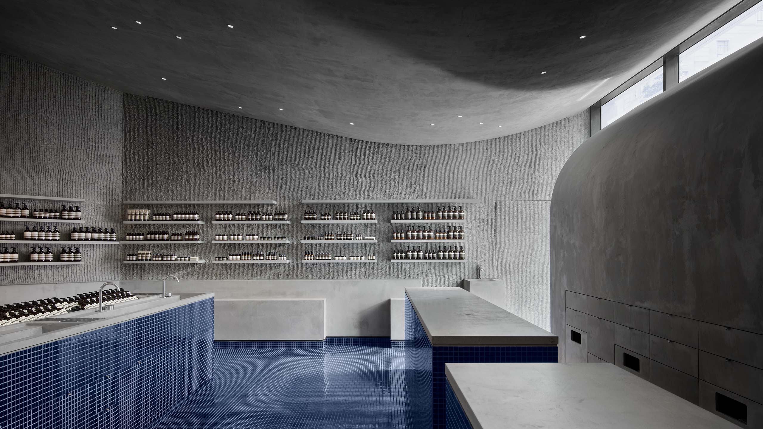 Grey concrete interior that features smooth, curved concrete wall and ceiling.