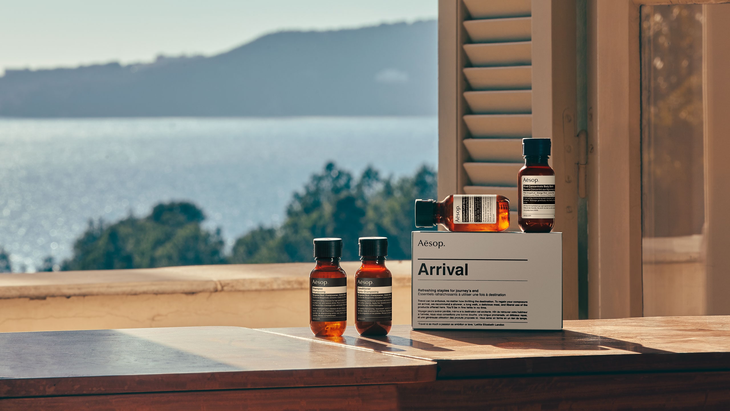 Aesop products in front of a window looking out to the ocean and blue sky