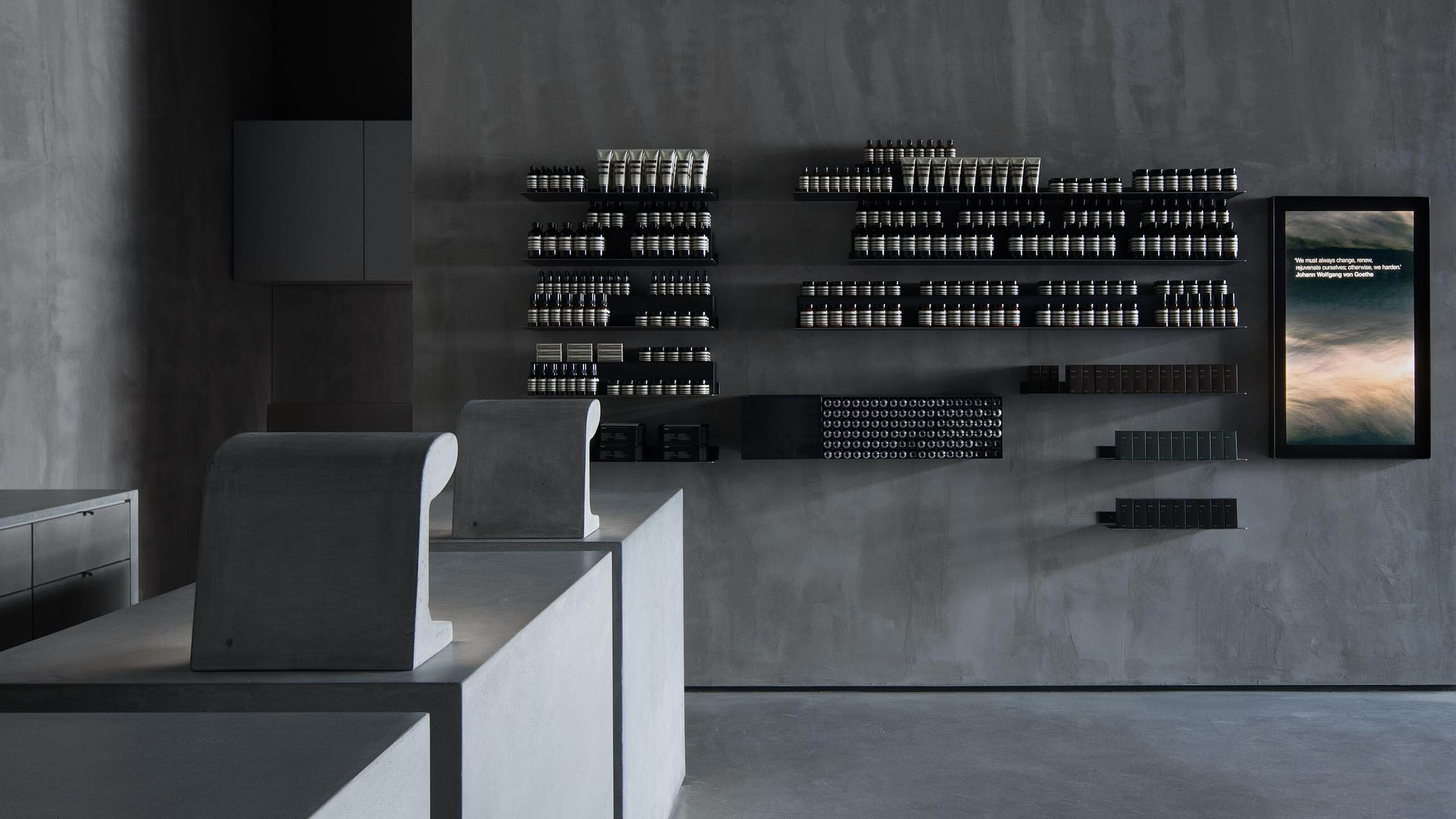 Brushed concrete interior. Several shelves line the concrete wall. 