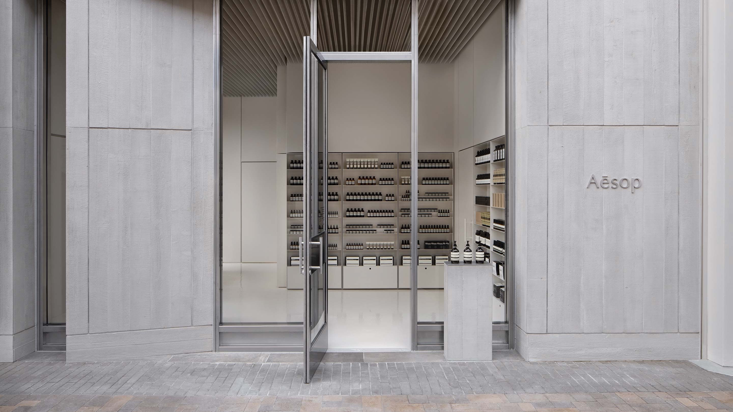 Aesop store entrance; featuring concrete, brutalist architecture. 