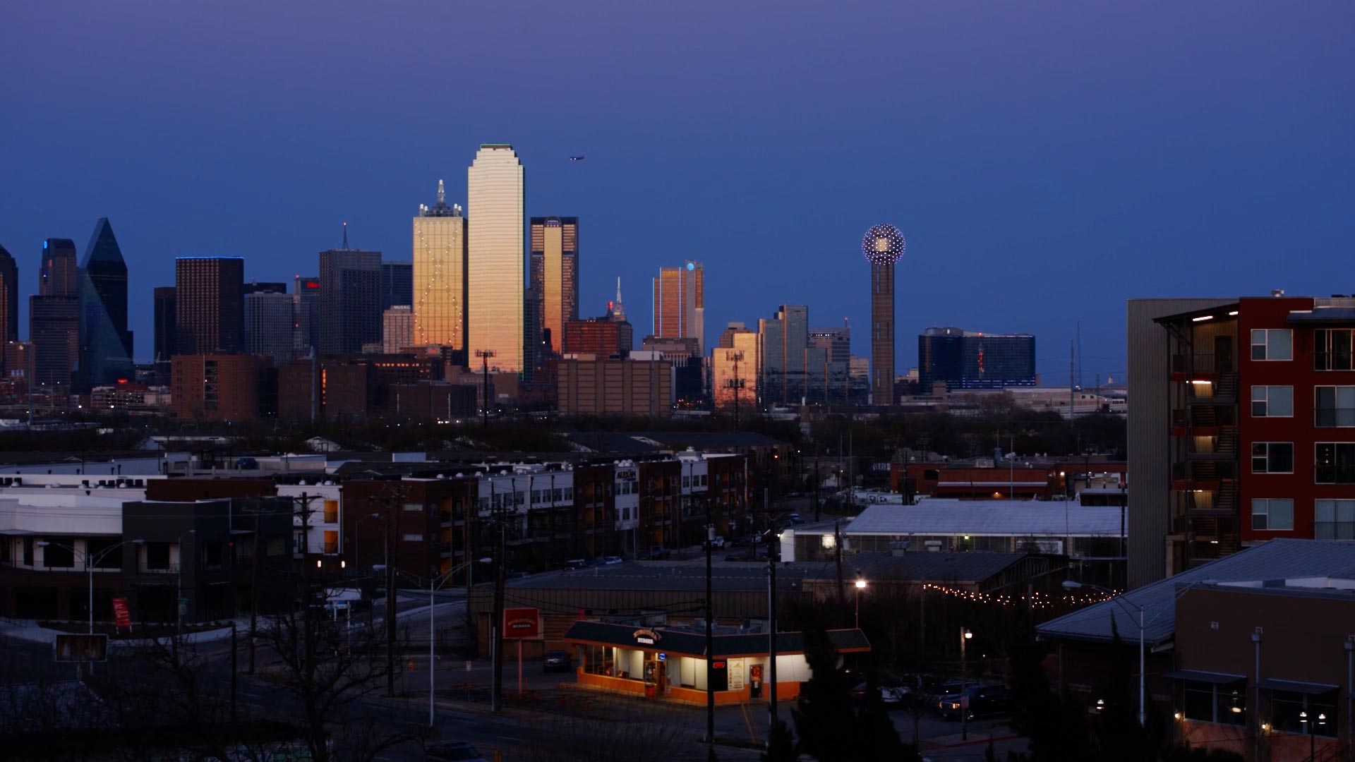 Long shot of city skyline at dusk.