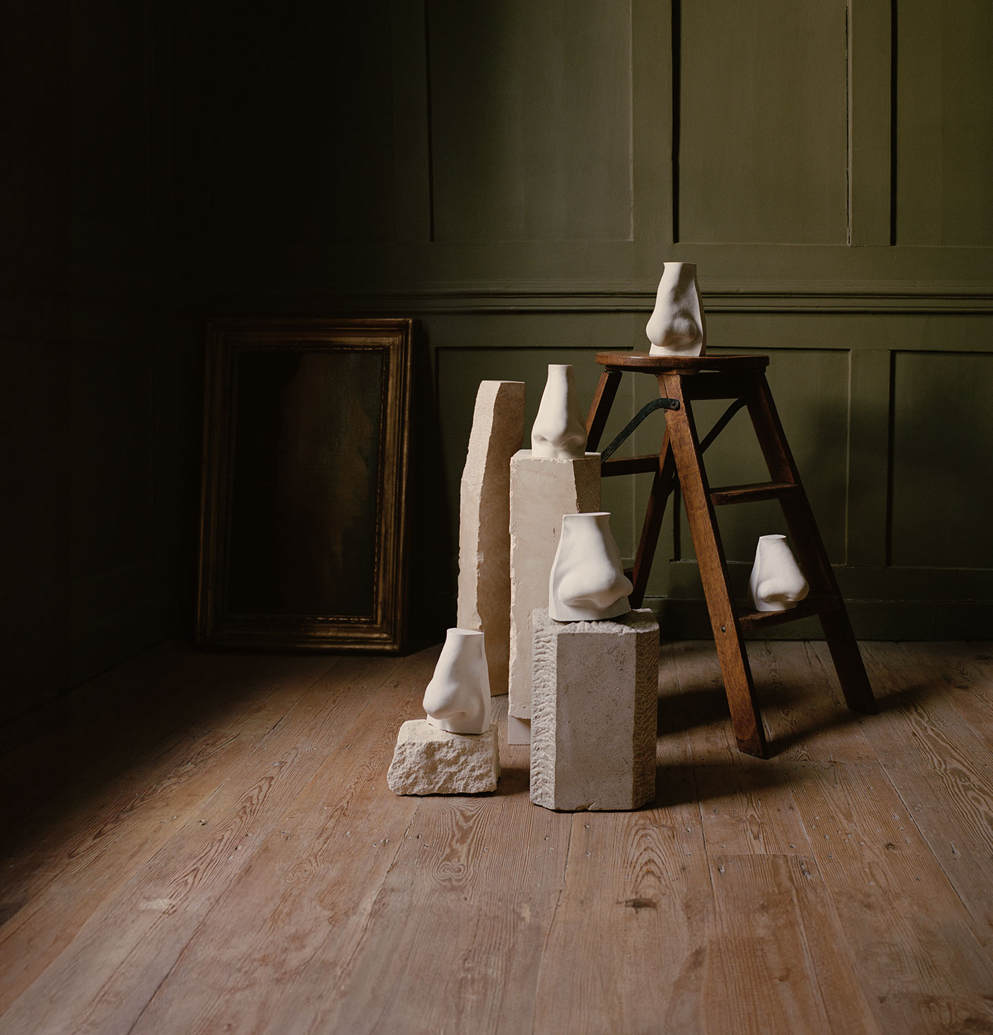 Nose sculptures placed on a wooden stool and marble stands