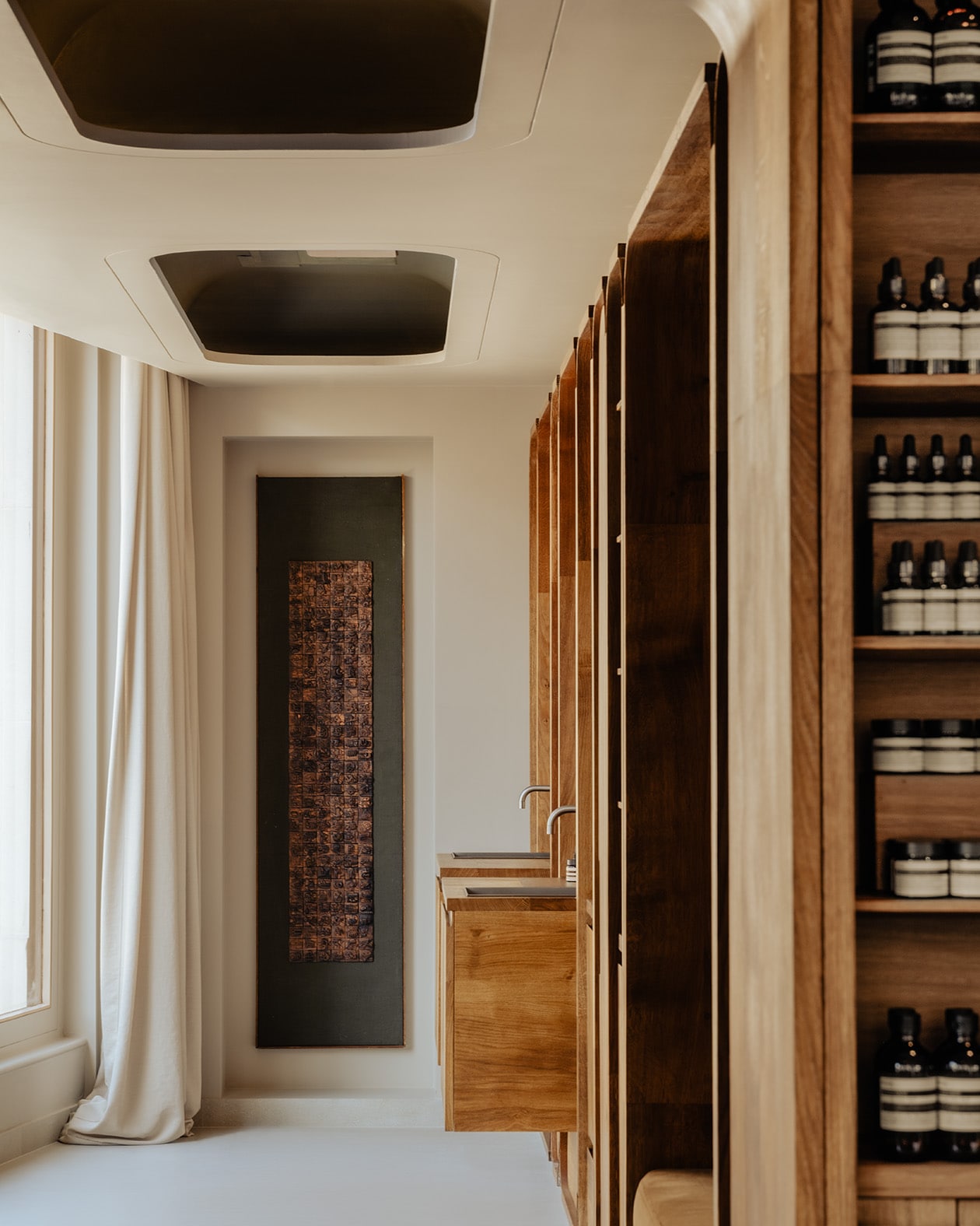 store interior featuring wall hanging in the backgound, side view of two sinks, and a cut off view of products on shelves