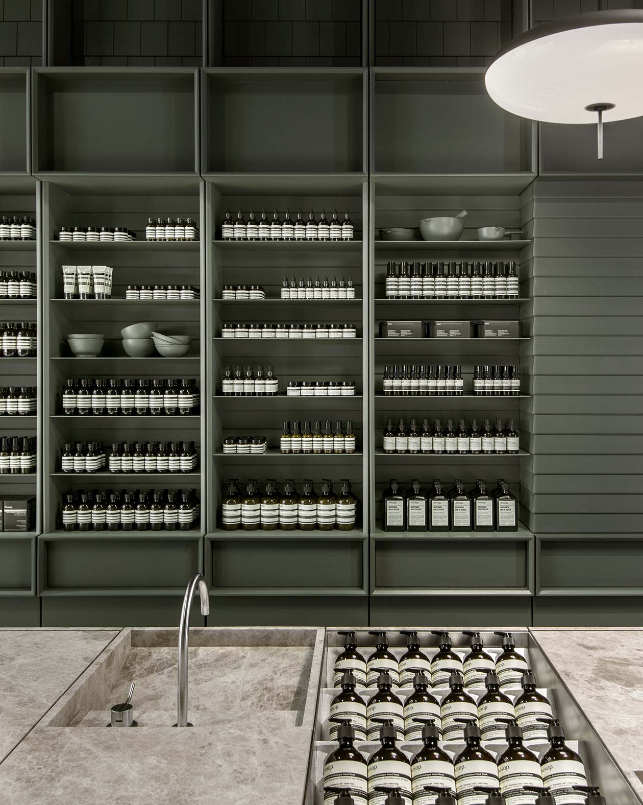 Aesop San Francisco store interior, looking past marble basin onto product cabinetry
