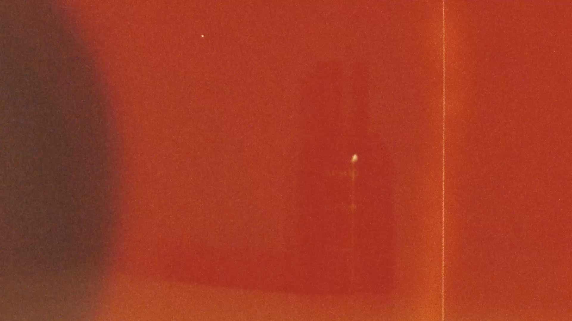A silhouette of Ouranon EDP bottle behind the red textured filter