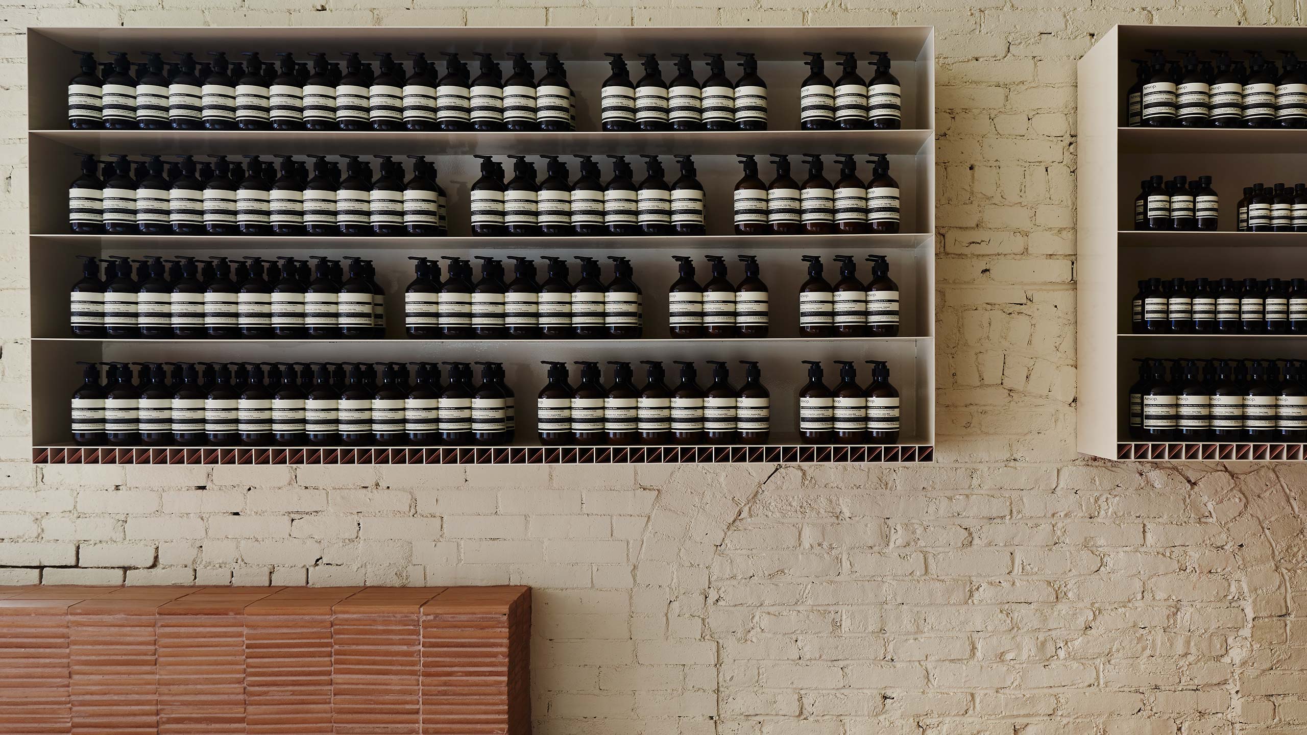 A close-up shot of a pair of product cabinets attached to a white-brick wall.