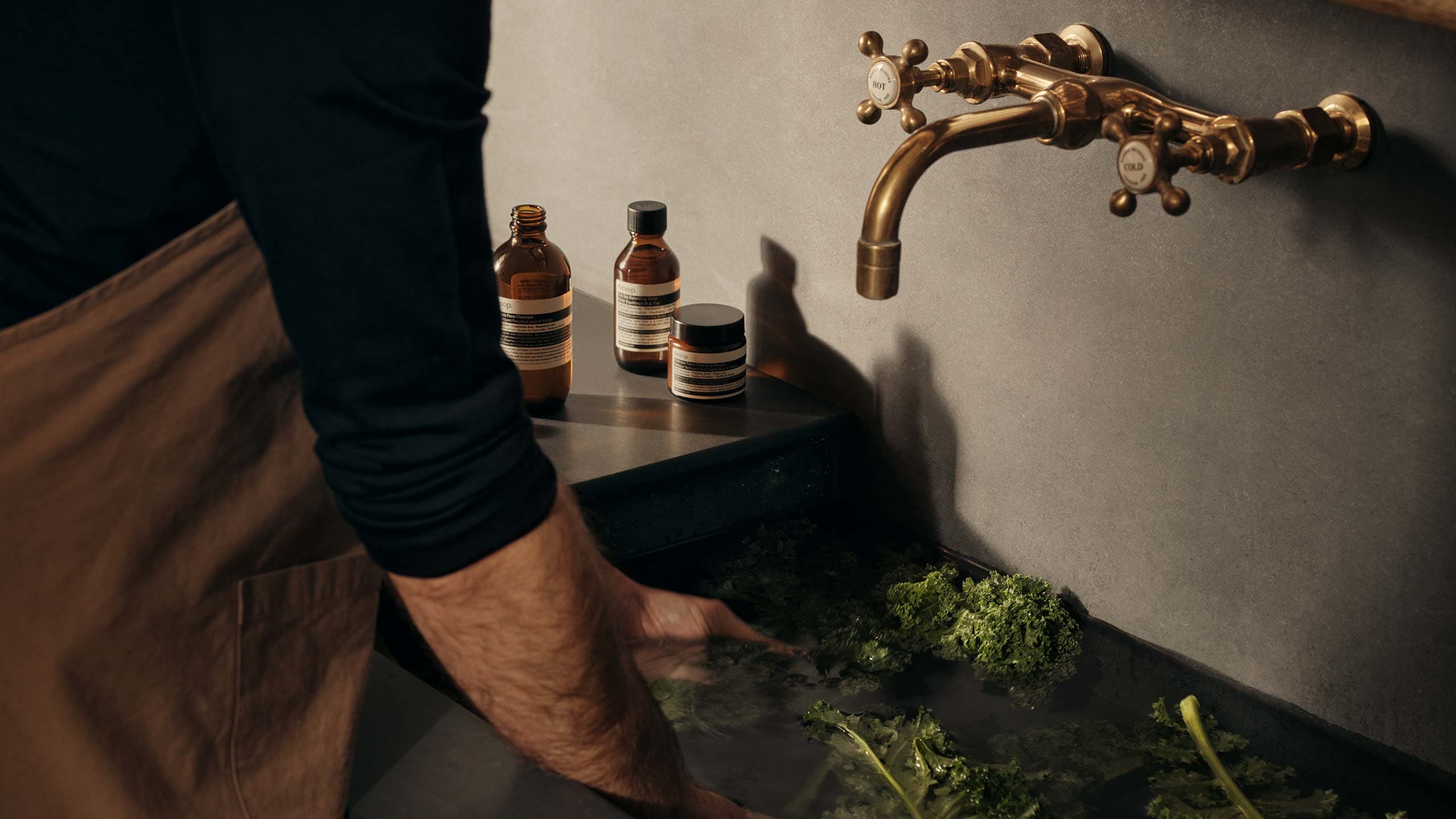 Kale being washed in a sink.