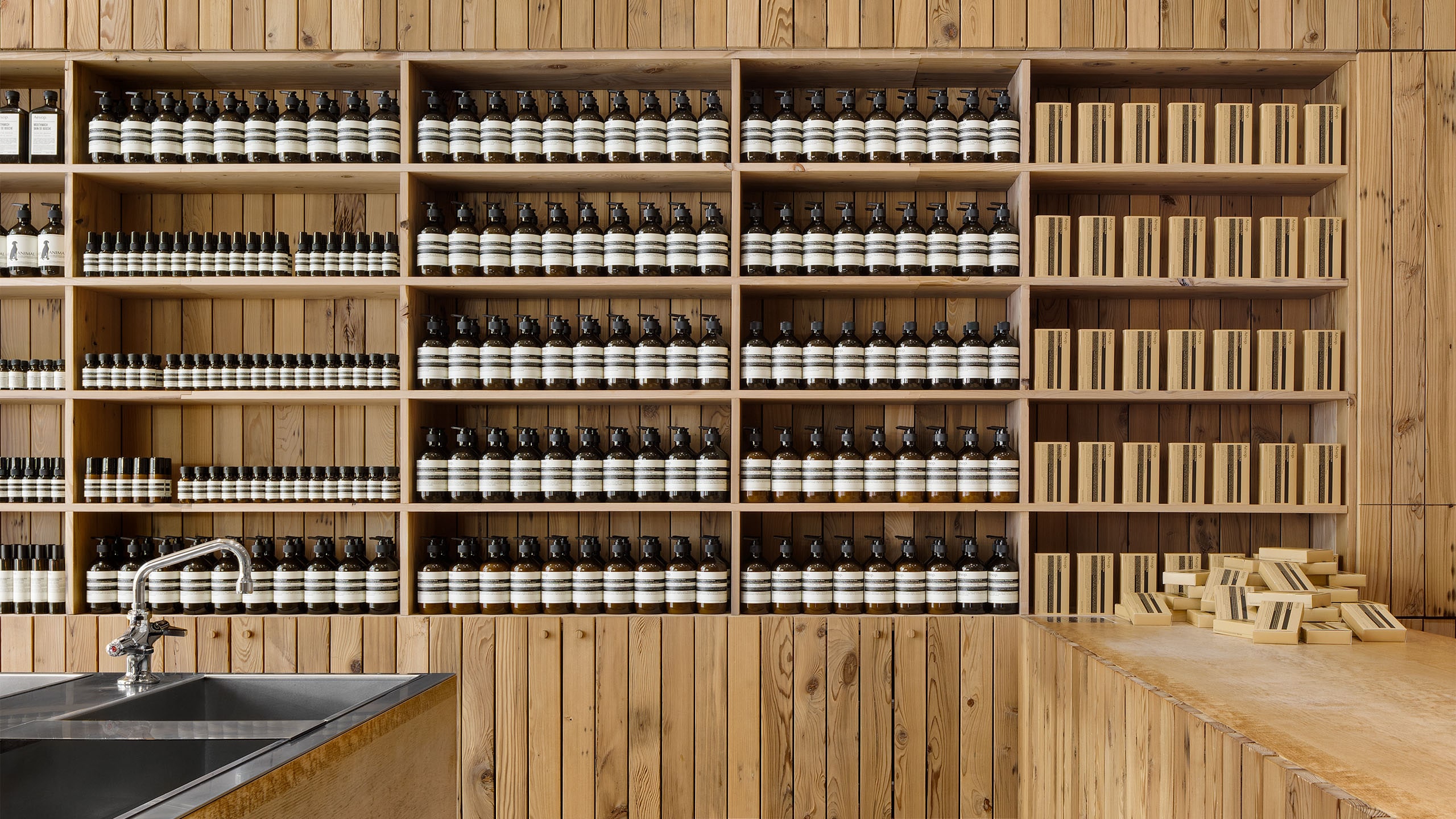 Store interior featuring reclaimed timber wall cladding; a steel sink featured in the centre