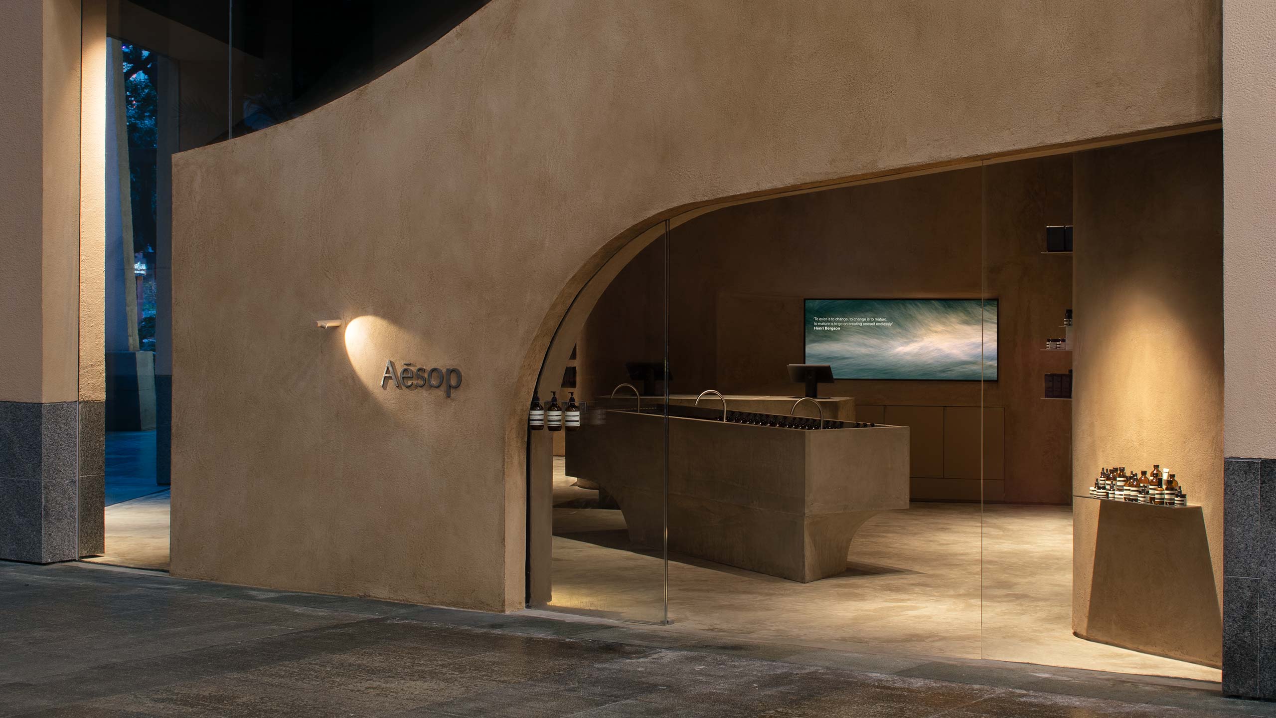 Exterior view of the store showing its beige, curved, naturalistic features. 