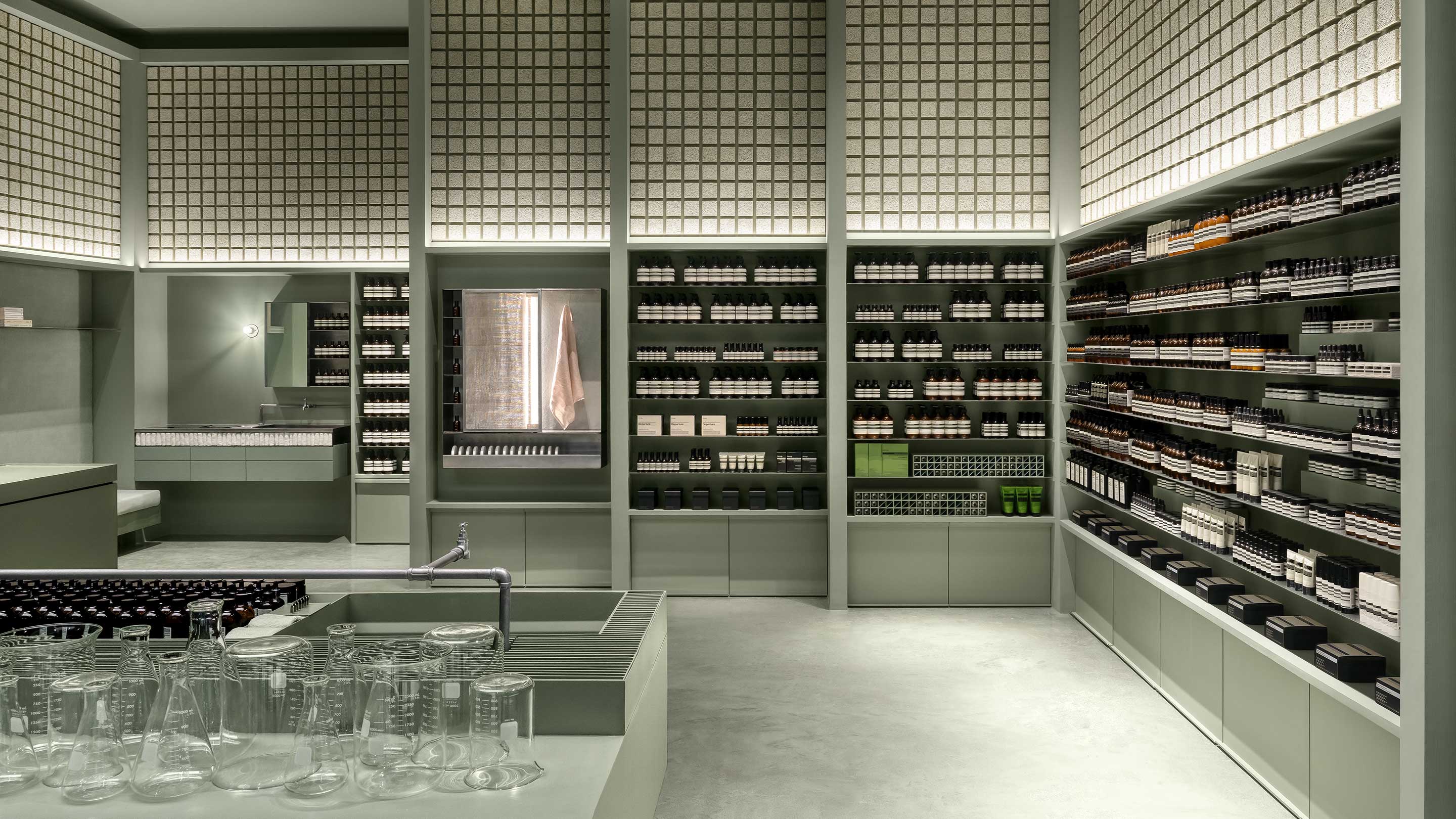 Aesop products line up in a store which wall made by tile