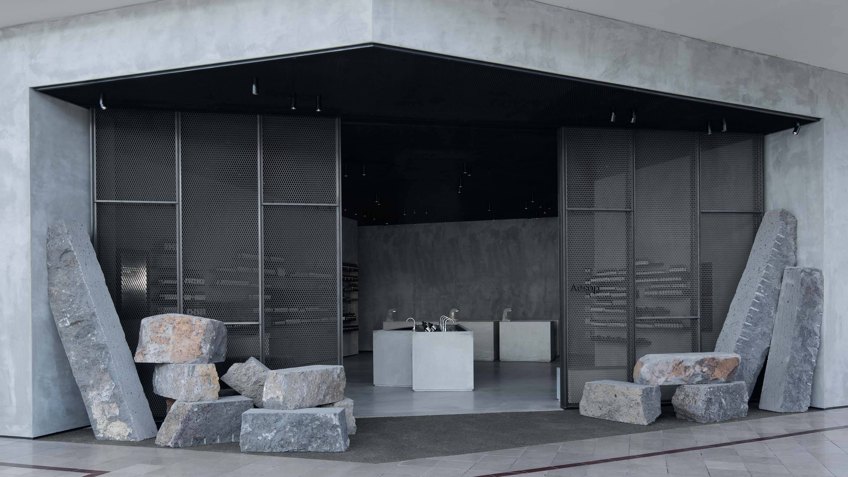 The grey exterior of the store. The entrance is surrounded by monolithic chunks of basalt