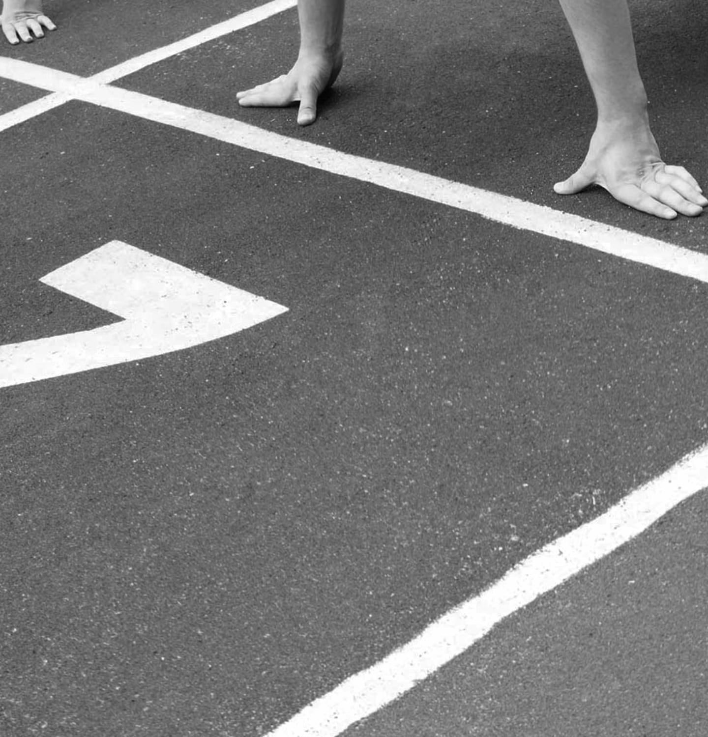 Runners preparing to start the race on an athletics track.