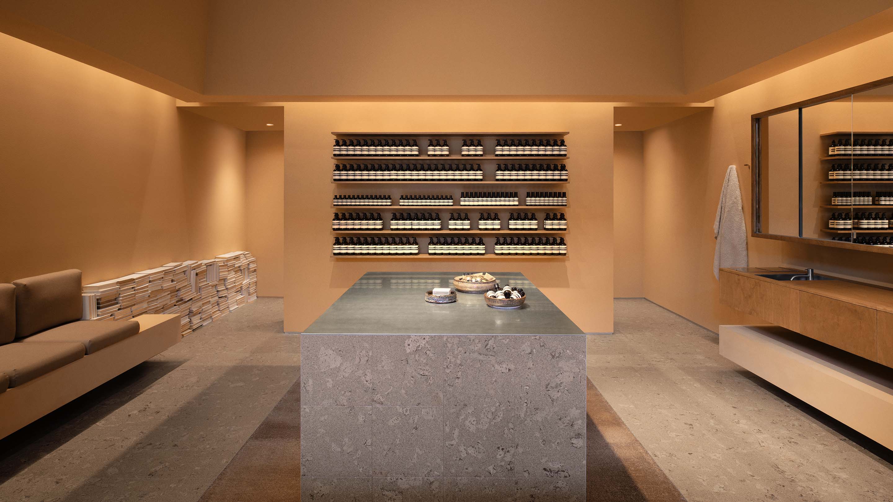 The store interior featuring marble counter top and  wooden shelves with products.