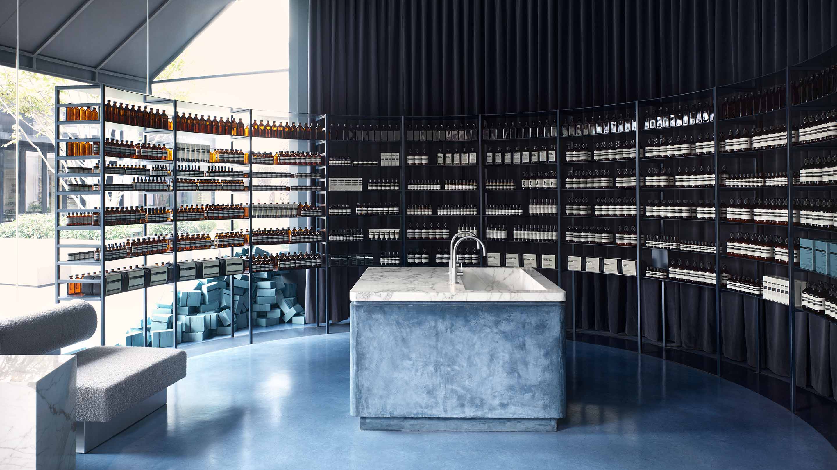Aesop UTC store interior, feautring monolithic marble basin with metallic minimalist taps and product on shelves in the background