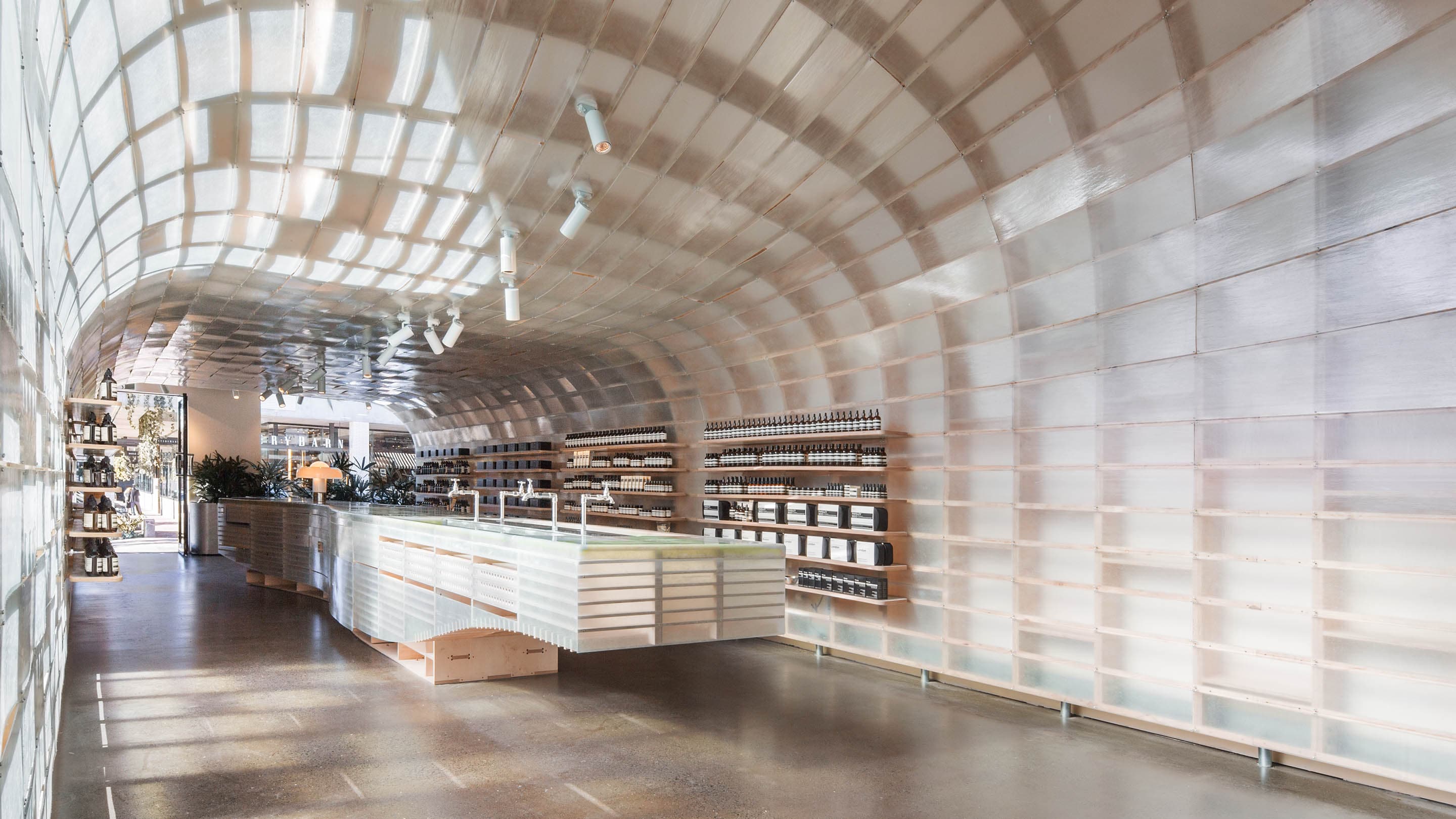 A curved translucent interior constructed from fiberglass. In the centre of the store is a long bright, white customer service basin.