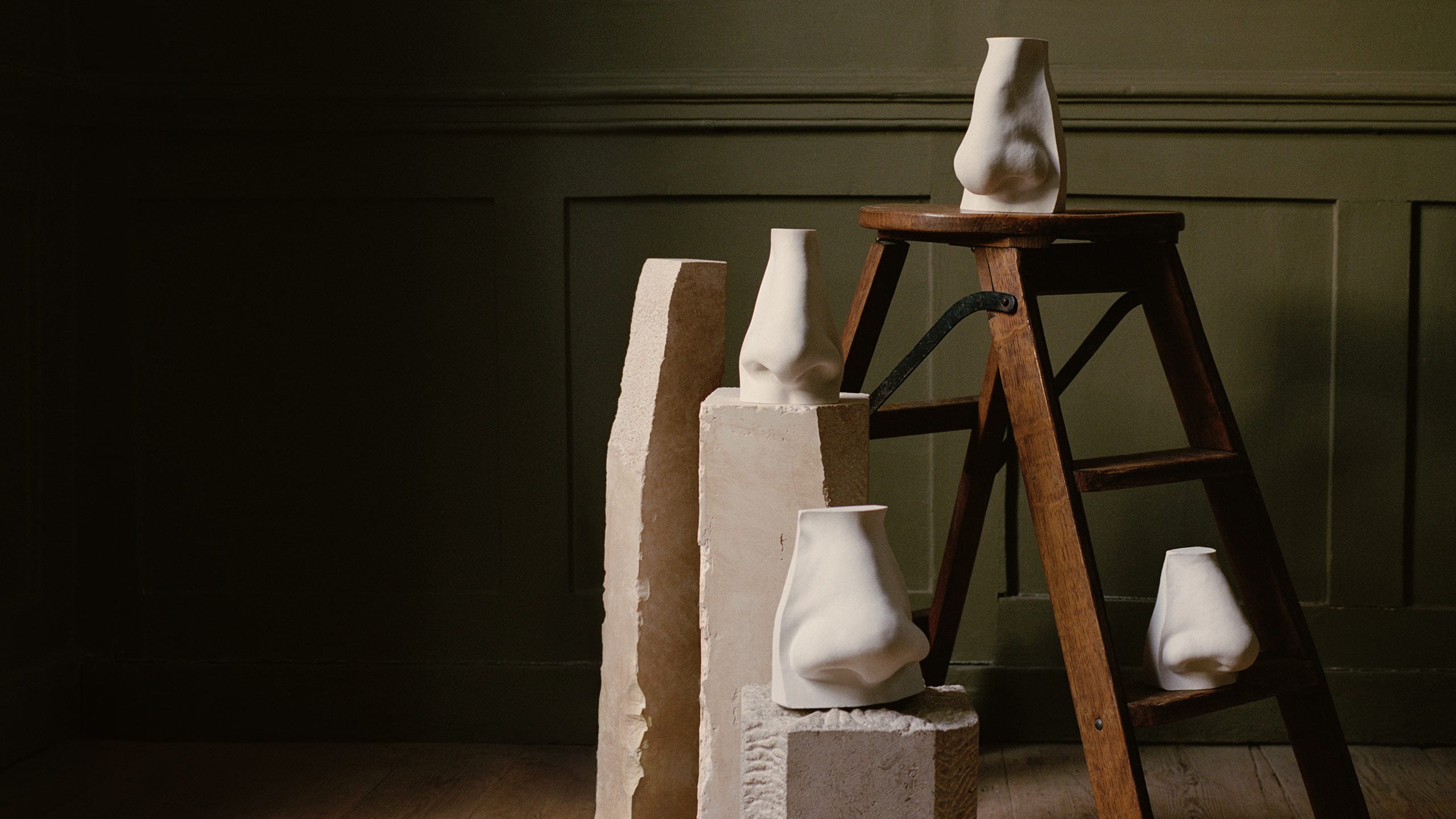 Nose sculptures placed on a wooden stool and marble stands