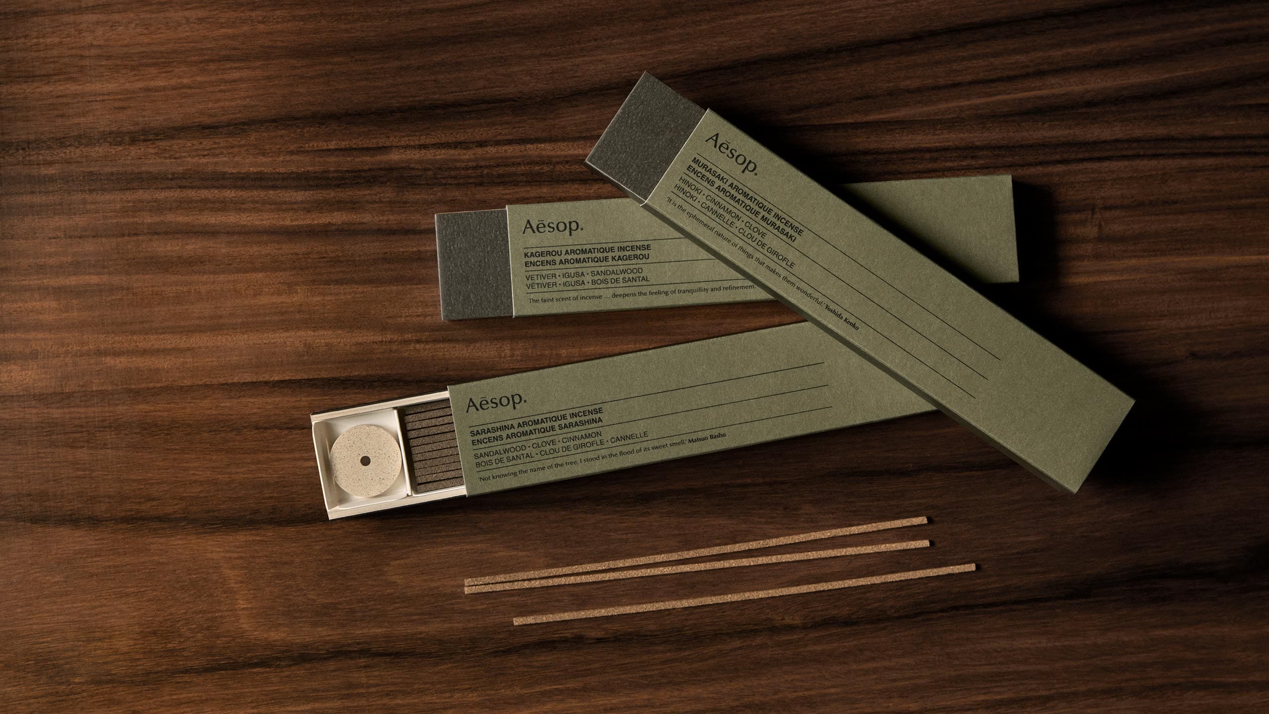 Three cartons of incense resting on a wooden surface.