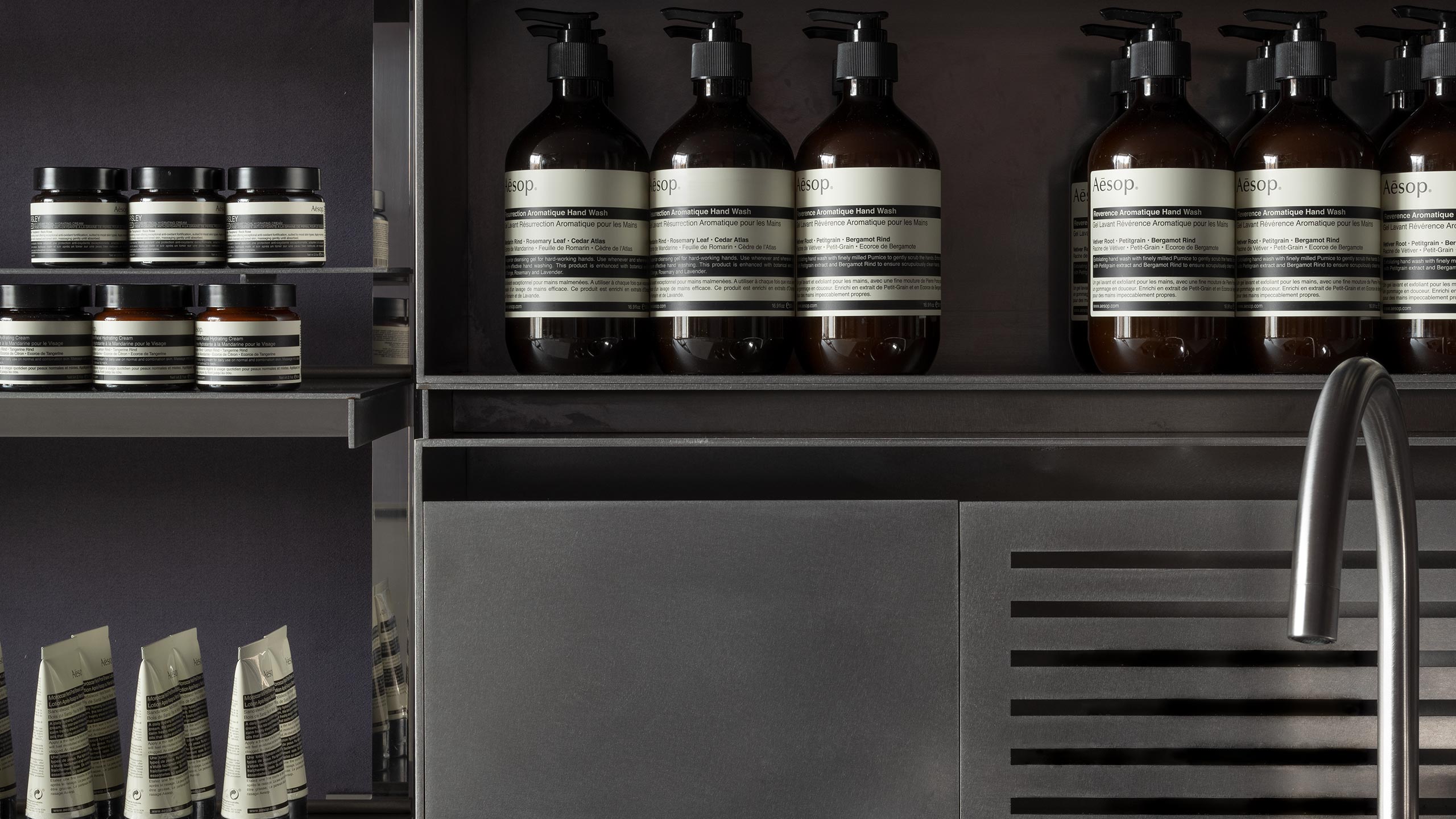 Close-up of steel shelving exhibiting its industrial design; holding Resurrection Aromatique Hand Wash.
