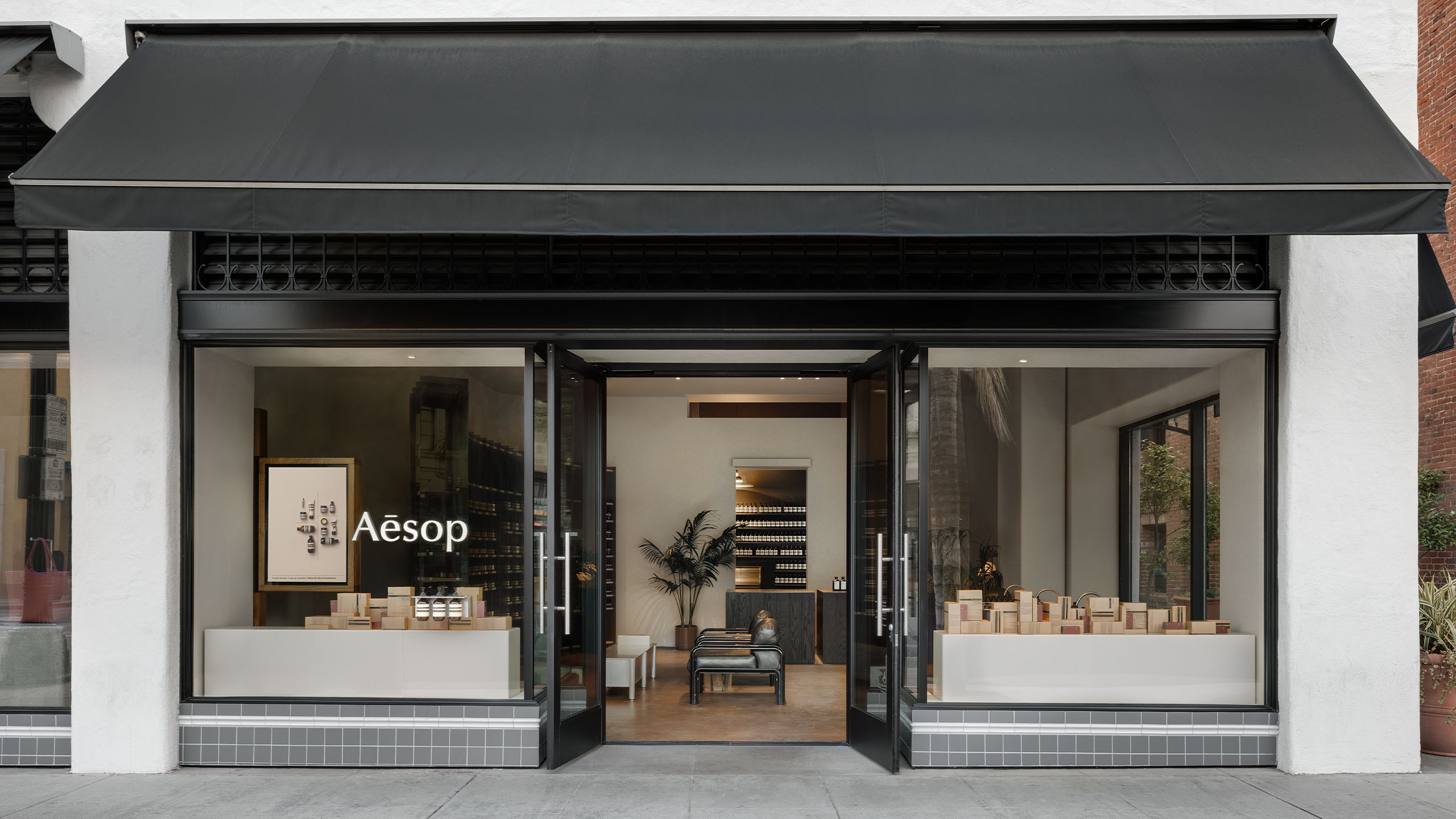 Street view of store entrance featuring dark grey tiled windows