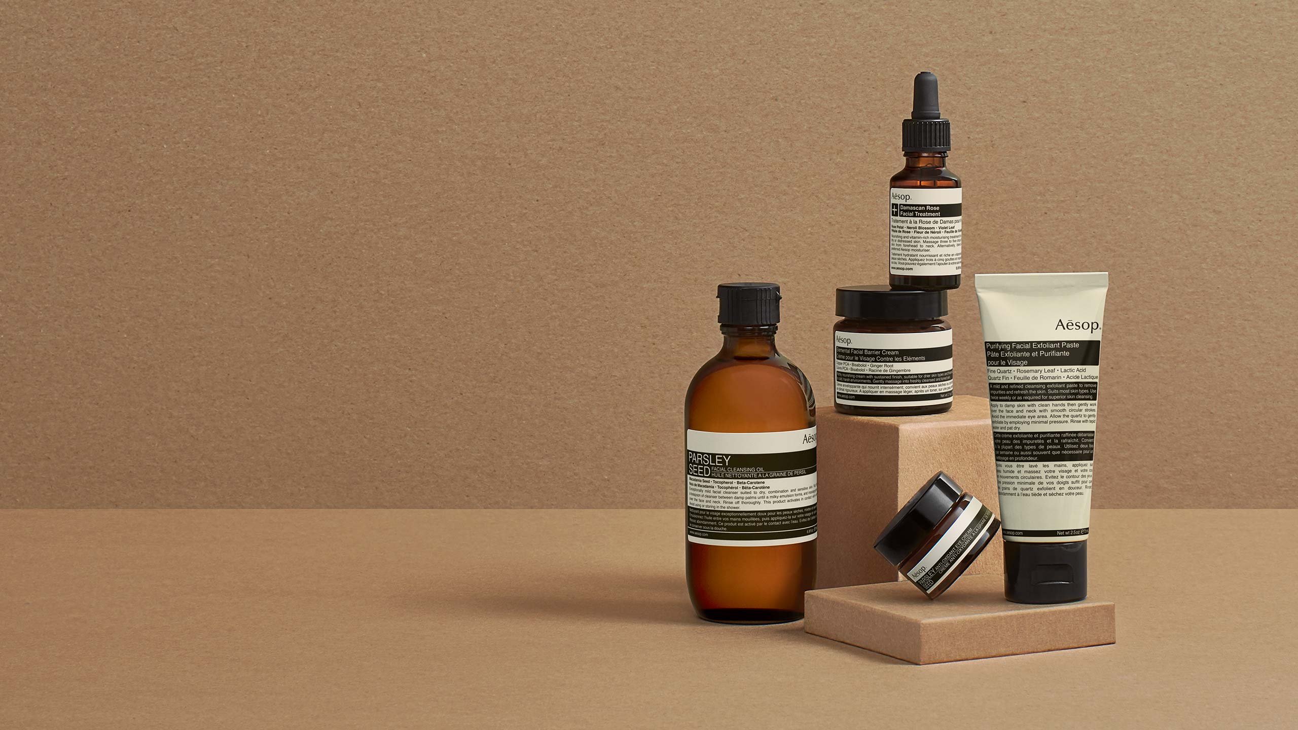 A collection of Aesop products in front of a brown background