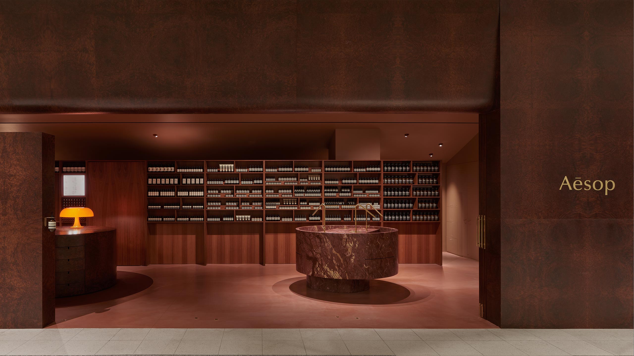 An exterior view of the Canberra store, that features a marble basin as the centrepiece. On the left, there is the customer service desk, with a vintage, orange mushroom lamp.