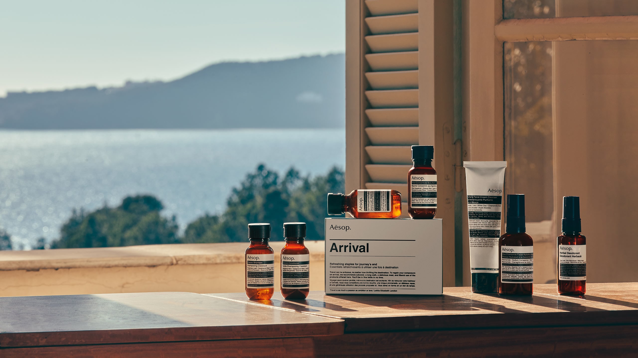 Aesop products in front of a window looking out to the ocean and blue sky
