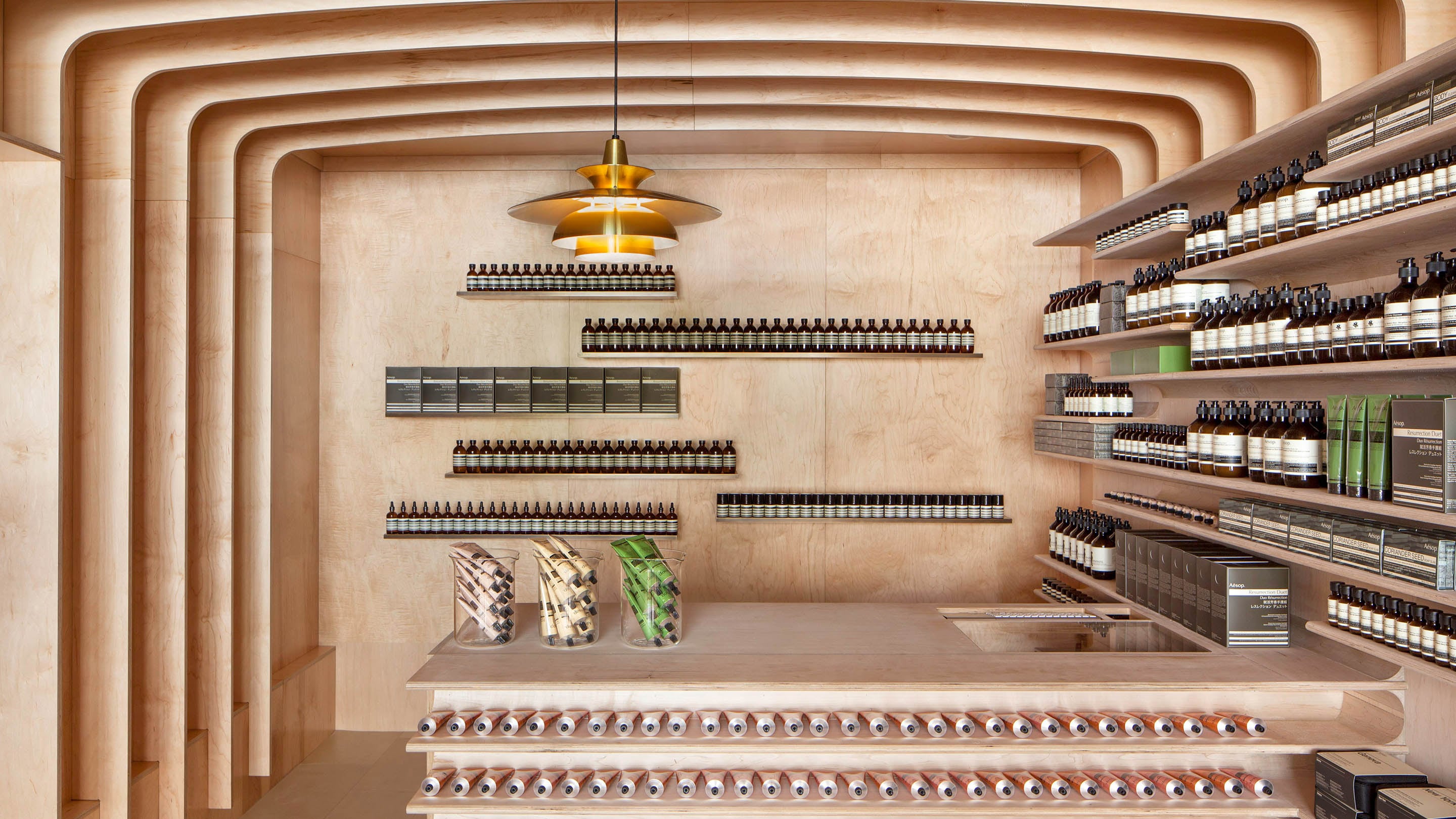 A store counter with curved plywood frames surrounding.