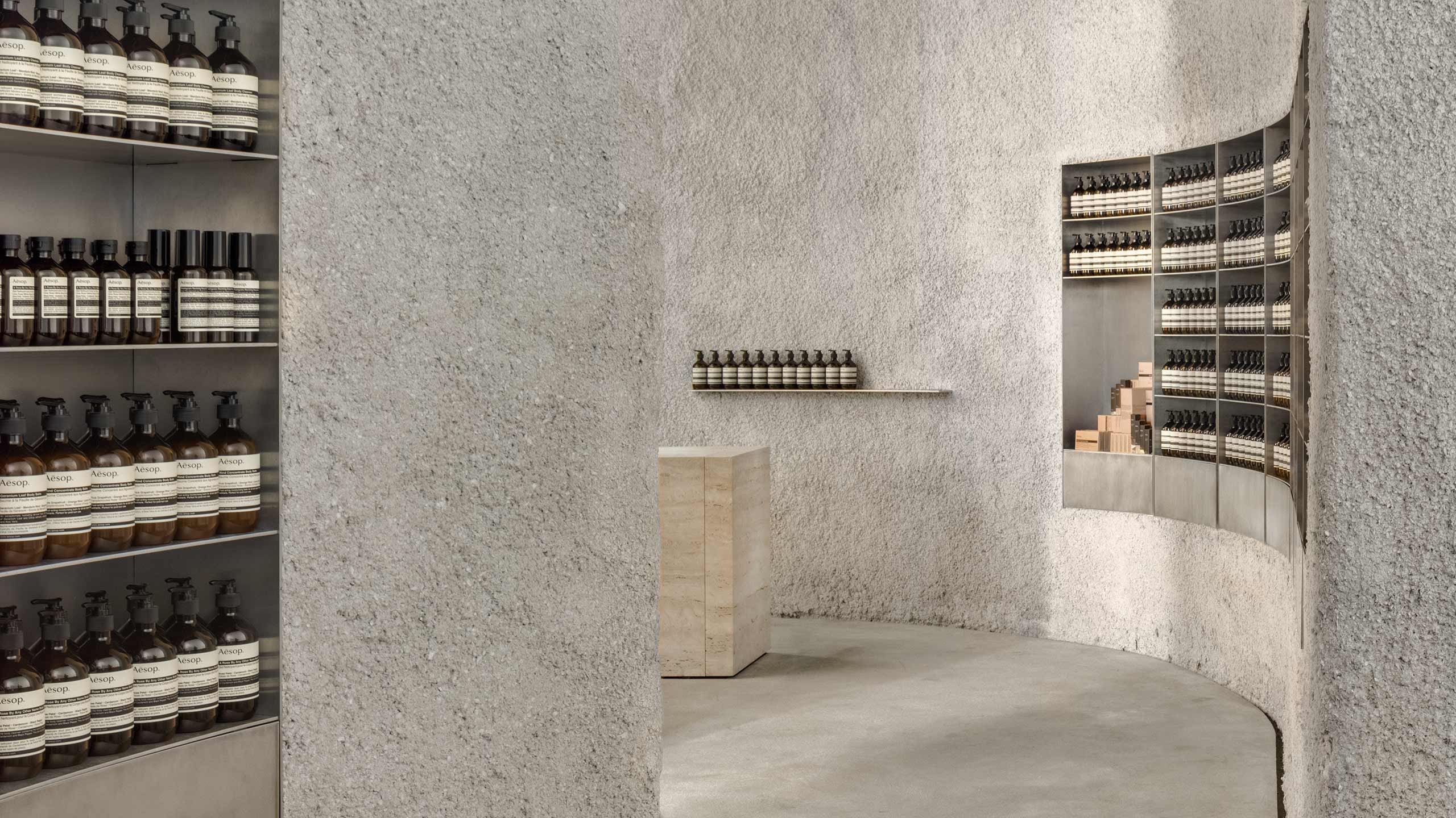 A curved passage towards the counter with product sitting neatly in the shelves.