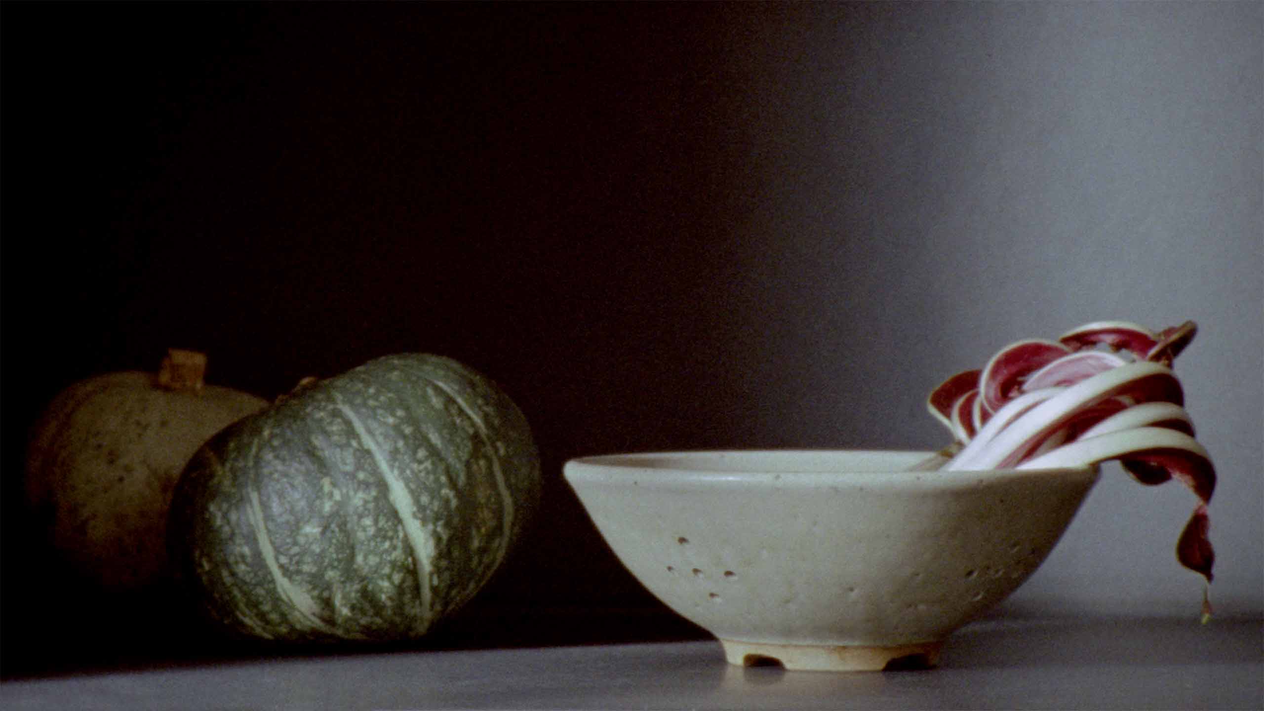 Ceramic bowl sitting alongside vegetables.