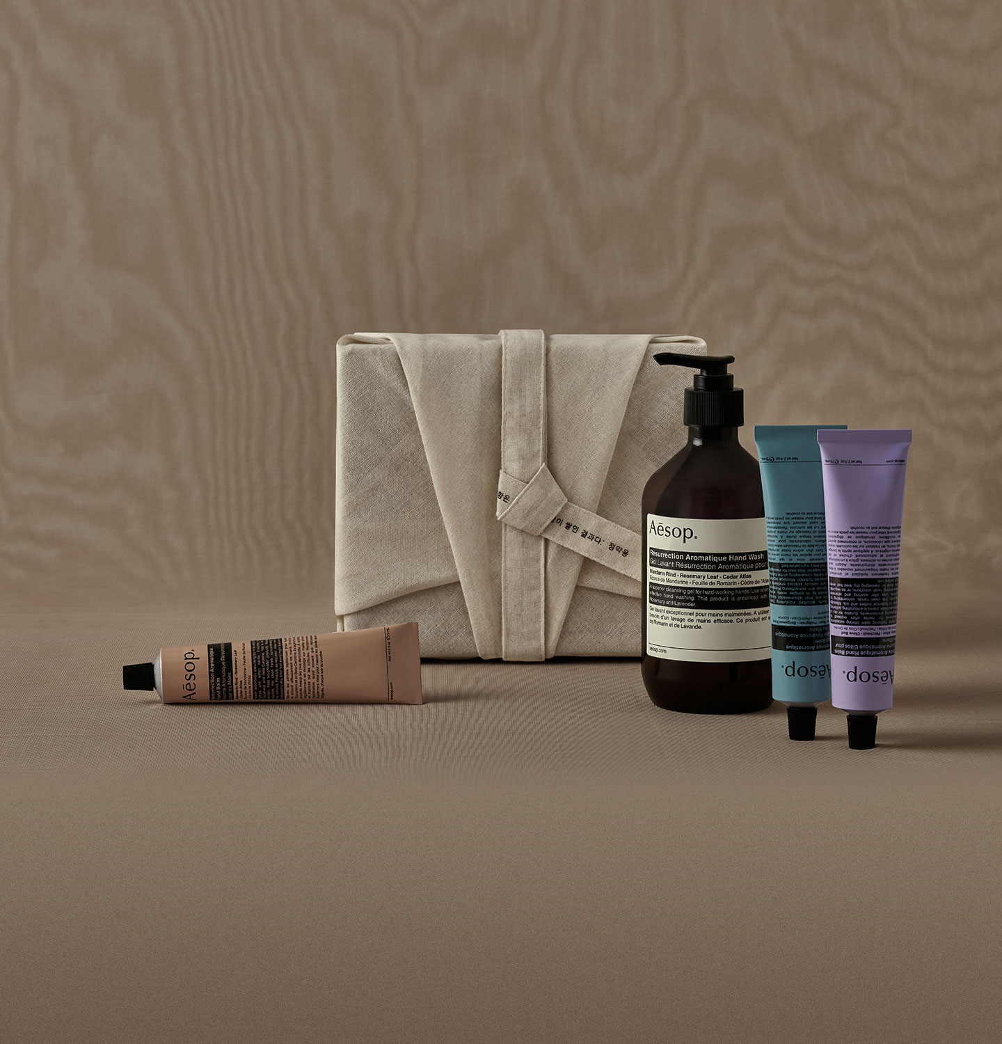 Aesop hand care products with bojagi wrapping in a beige background
