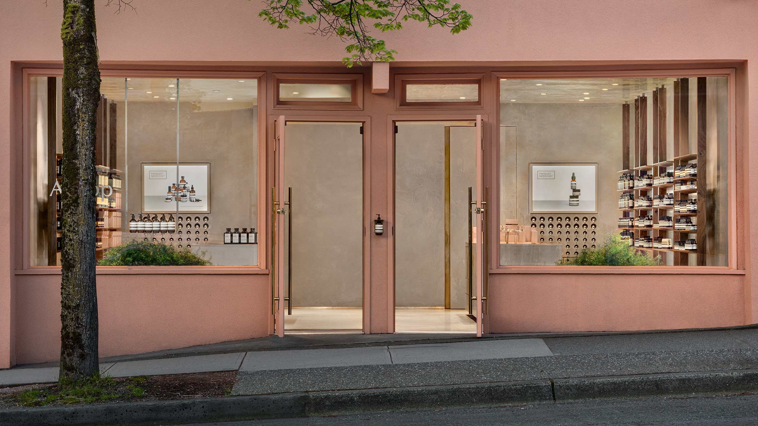 A street view of the pastel-pink entrance at Aesop Kitsilano. 