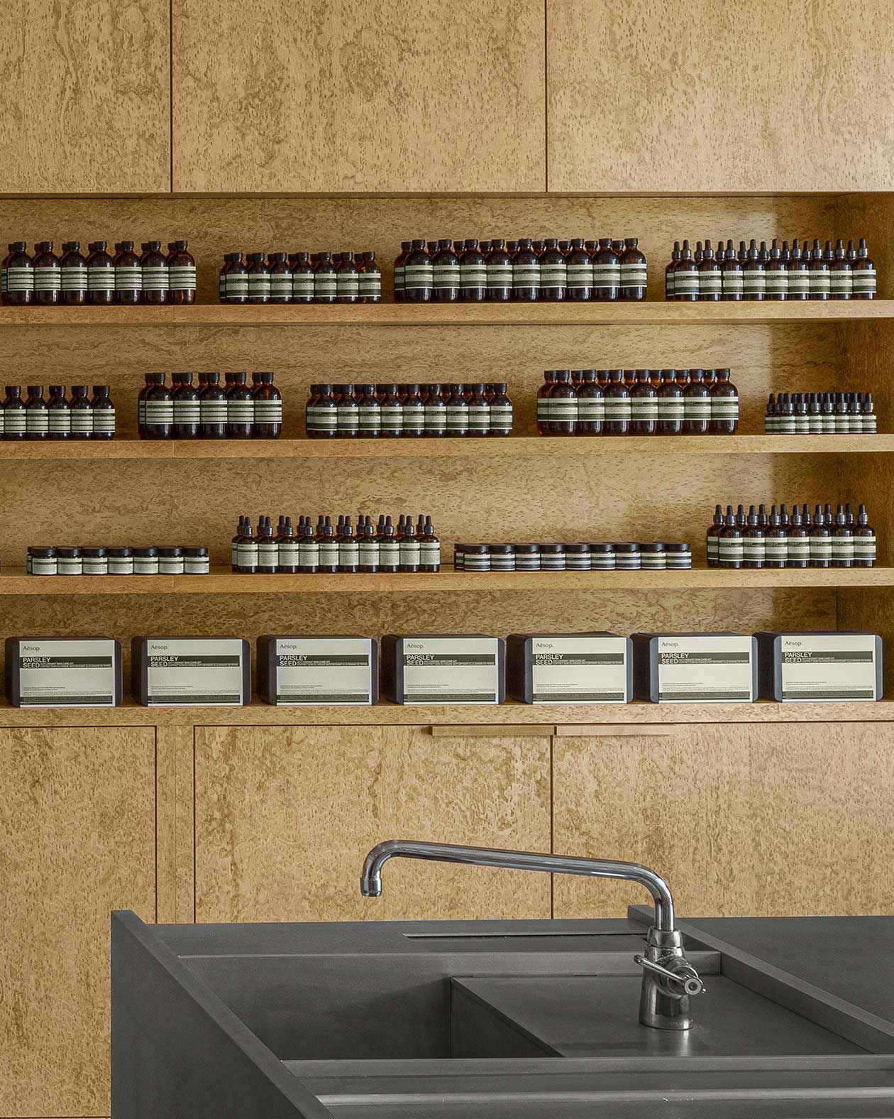 Aesop Yorkdale store interior, featuring mettalic basin in front of product cabinetry.