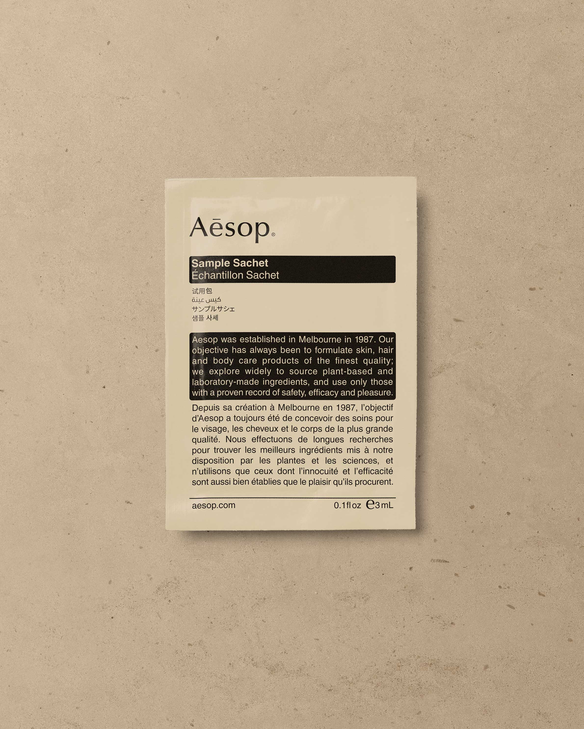 An Aesop sample sachet resting on a textured surface.