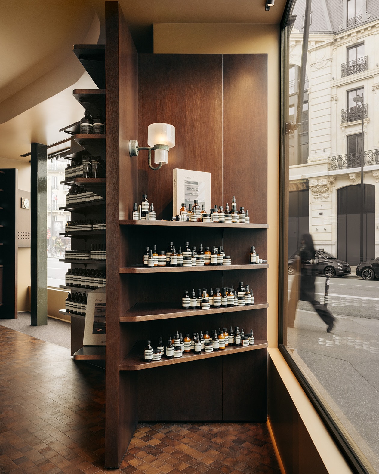 Aesop Rue de Sèvres store interior product display shelves lined with Aesop amber bottles.