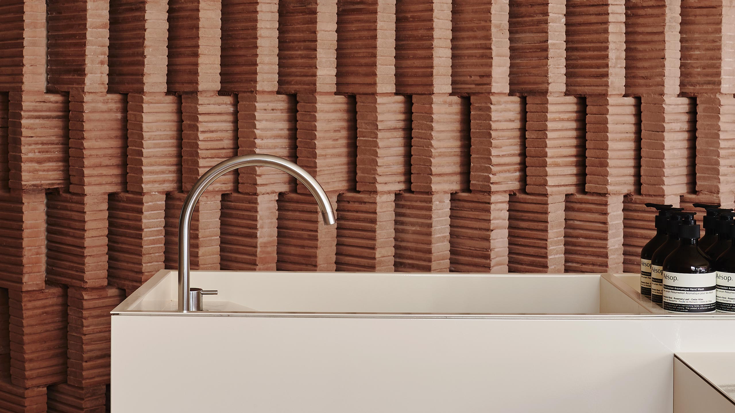A close-up shot of the basin at Aesop Park Slope, backdropped by a tessellated brick wall.