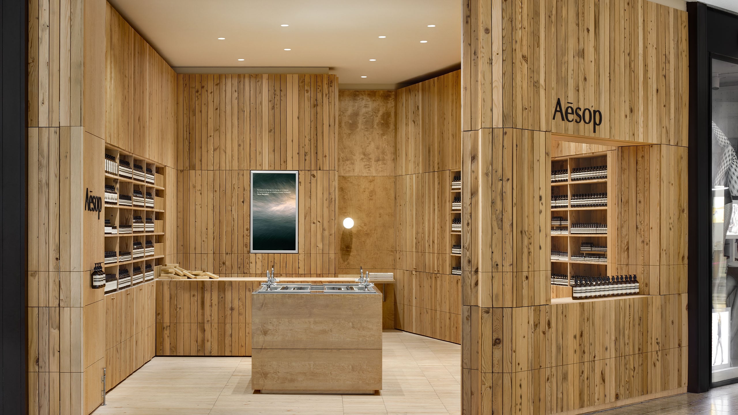 A wall of shelves made from reclaimed timber holding Aesop product