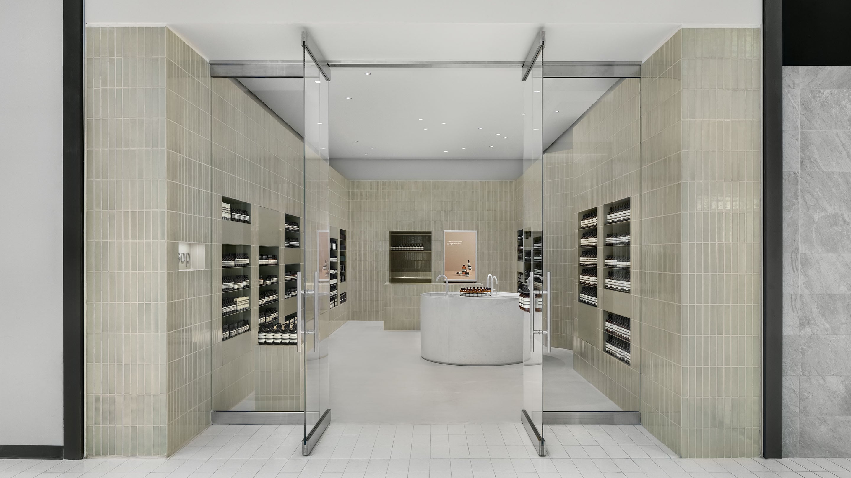 Pale-light green tiles surrounding the glass entrance to Aesop Rideau Centre store