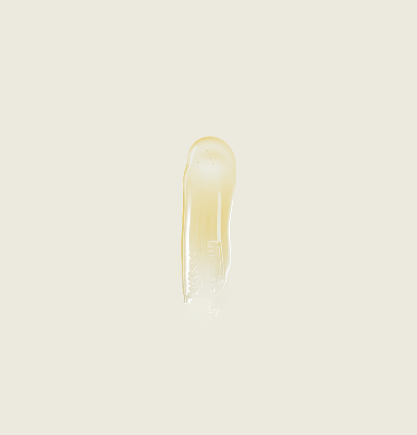 Eine großzügige, löffelgroße Menge bernsteinfarbenes Gel läuft über die Seiten eines Löffels aus Metall in den Glastiegel. 