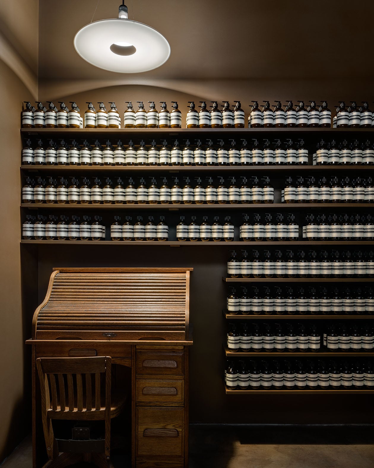 Vintage writing desk surrounded by shelves of Aesop product.