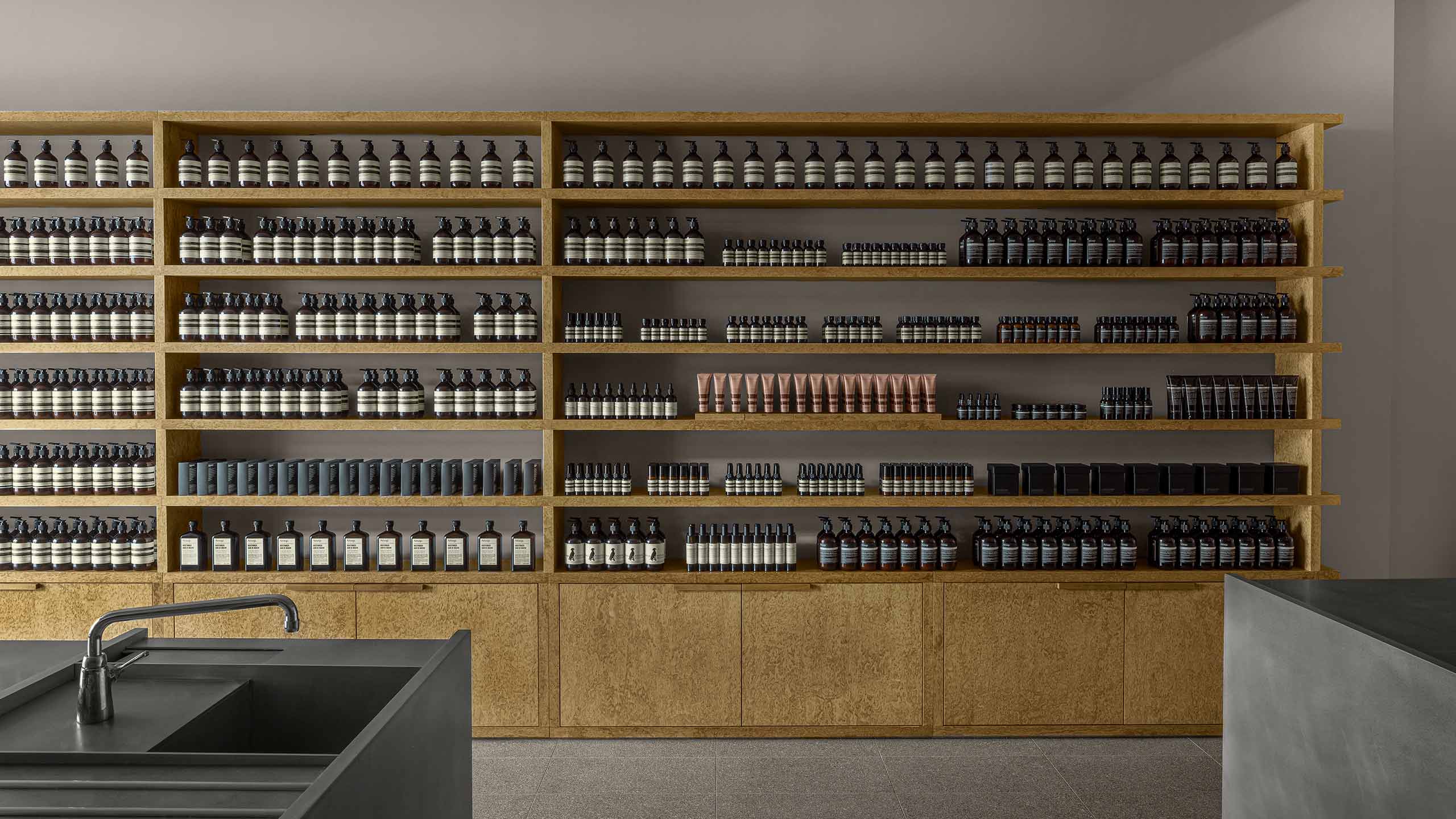 Aesop Yorkdale store interior, featuring large wooden product cabinet against wall.